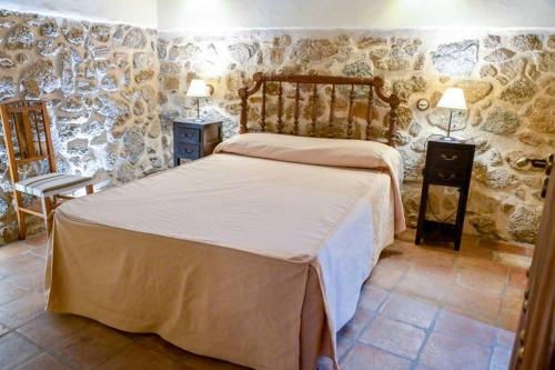 CaleruelaUn espacio único, 'La Casona del Señor' con bodega的一间卧室设有一张床和石墙