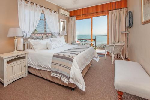 戈登湾18 On Kloof Guest House的一间卧室配有一张床,享有海景