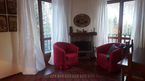 克拉维埃coeur de neige的客厅配有2把红色椅子和壁炉