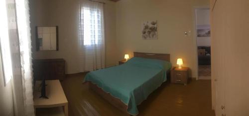 安德罗斯Kontos-Traditional house in Andros beach的一间卧室设有一张床、一个窗口和一台电视