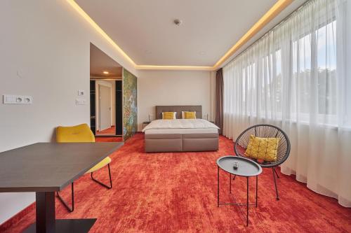 赫拉德茨 - 克拉洛韦Hotel Hertz的卧室配有一张床和一张桌子及椅子