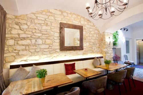 布拉格艾格尼斯居苑酒店的一间设有木桌和石墙的餐厅