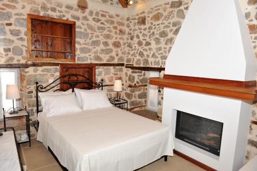 伊兹拉亚历山德拉旅馆的一间卧室配有一张床和一个壁炉