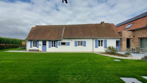 图尔奈Au Chant des Oiseaux的前面有绿色草坪的房子