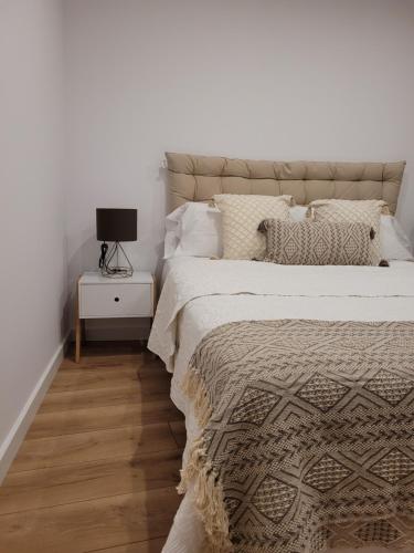普拉加德阿罗somtresapartament的一间卧室配有一张床和一个带灯的床头柜