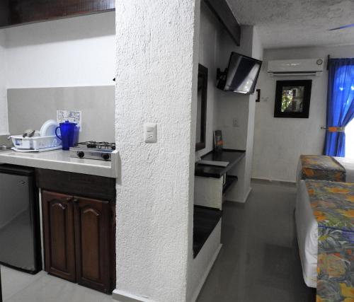 坎昆艾尔雷伊德尔加勒比经济型酒店的客房内设有带水槽和炉灶的小厨房
