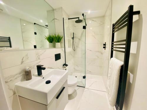约克10 Bootham House - luxury city centre apartment with free parking for one car的白色的浴室设有水槽和淋浴。