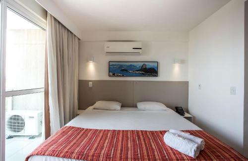 马卡埃Flat 804 - Conforto, praticidade e vista panorâmica em Macaé的一间卧室配有一张带红色毯子的大床
