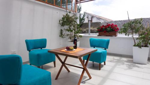 拉塔昆加REEC Latacunga by Oro Verde Hotels的天井上的桌子和4把蓝色椅子