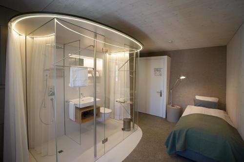 韦因费尔登Gasthaus zum Trauben的带淋浴的浴室和客房内的一张床