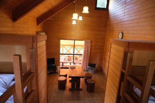 Oshuフォレストコテージ奥州的小屋内的房间设有木桌和长凳