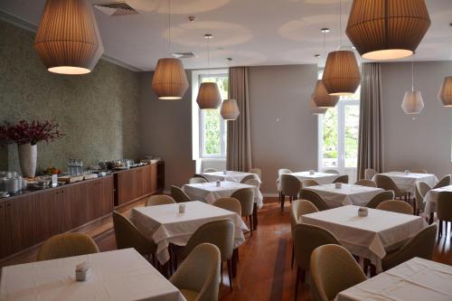 布拉加公园酒店的餐厅设有白色的桌椅和柜台