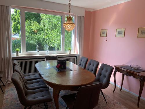 亚琛Villa Hortensie的一间带桌椅和窗户的用餐室