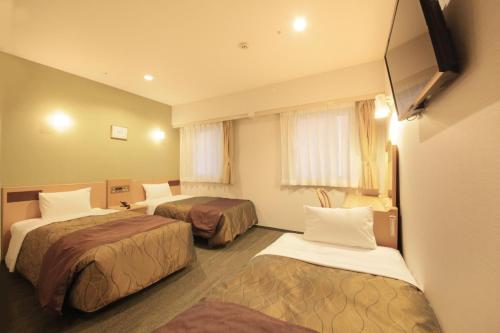东京大城市酒店的酒店客房设有两张床和电视。