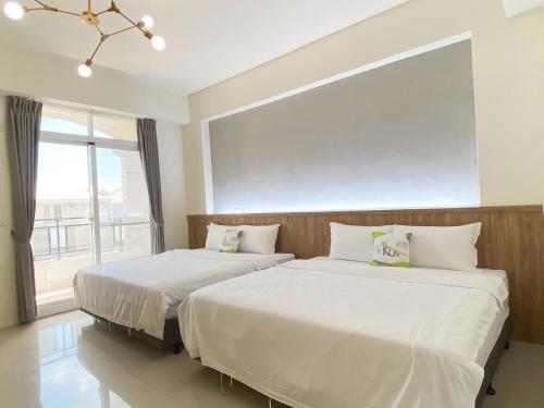 台东困家南岛馆的卧室设有两张床和大窗户