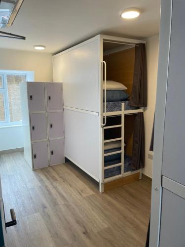 伦敦卡姆登斯马特旅舍的客房设有大型白色橱柜和一张双层床。