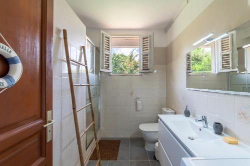 勒拉芒坦Villa Ti'Kemy avec piscine au sel的一间带水槽和卫生间的浴室以及窗户。