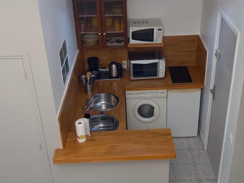 马恩河畔的尚格尼STUDIO PROCHE PARIS ET DISNEYLAND PARIS的带微波炉和洗衣机的小厨房