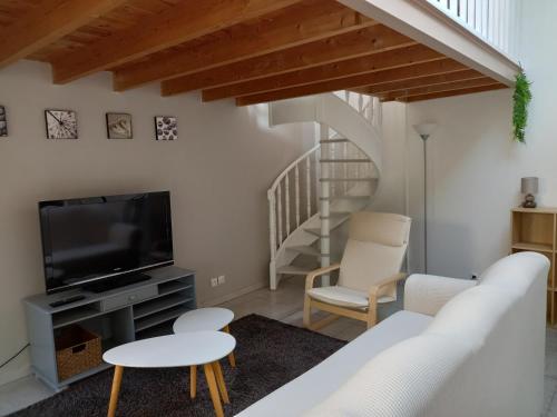 马恩河畔的尚格尼STUDIO PROCHE PARIS ET DISNEYLAND PARIS的一间带电视和椅子的客厅以及楼梯