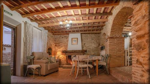 Fuente del ArcoCasa Rural La CasAna的客厅设有木制天花板和桌椅