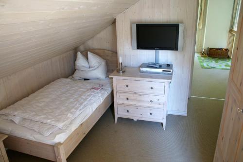 巴贝Ferienhaus-Kinderlieb的一间卧室配有一张床、一台电视和一个梳妆台