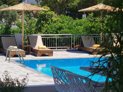 赫索尼索斯Mitos Village的游泳池旁设有椅子和遮阳伞