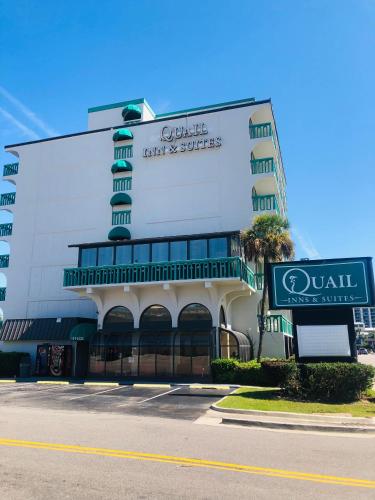 默特尔比奇Quail Inn and Suites - Myrtle Beach的前面有标志的大建筑