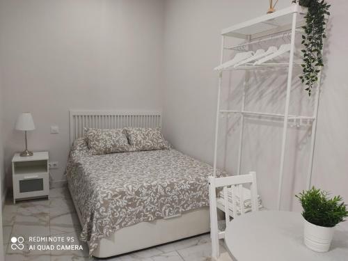 马德里Estudio 2 personas Wifi fácil acceso centro de Madrid的白色卧室设有床和架子
