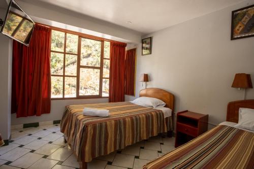 马丘比丘拉派查旅馆的酒店客房设有两张床和窗户。