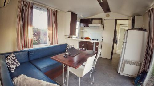 布拉格Triocamp Praha的一间带蓝色沙发和桌子的客厅以及一间厨房