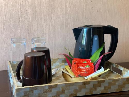 格兰贝伊Ocean Lake Tourist Residence的咖啡壶和柜台上的两个杯子