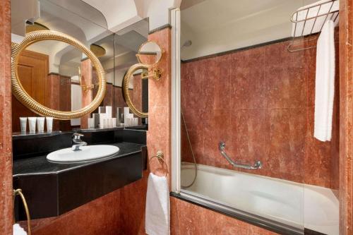 布鲁塞尔Hotel Avenue Louise Brussels Trademark Collection by Wyndham的一间带水槽和镜子的浴室