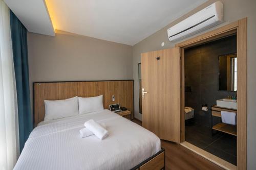 乔尔卢Çorlu Dem Hotel的一间带白色床的卧室和一间浴室