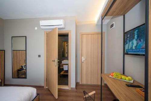 乔尔卢Çorlu Dem Hotel的一间卧室配有一张床和一张书桌及电视