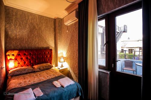 库塔伊西Hotel Balcony的一间卧室设有一张床和一个大窗户