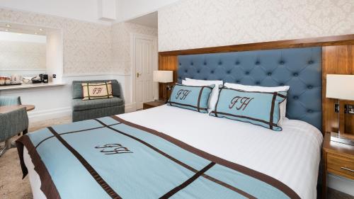 皮特洛赫里渔夫酒店的一间卧室配有一张大床和蓝色床头板