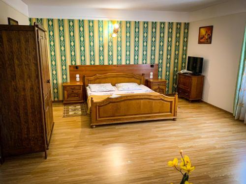 Rudna MałaHotel Wellness & SPA Antyczny Dwór的一间卧室配有木床和绿色壁纸