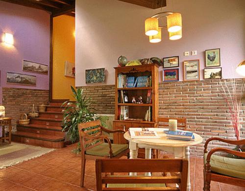 索托德坎加斯La Ablaneda的配有桌椅和砖墙的房间
