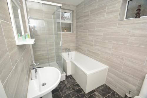 盖茨黑德Spacious and Homely 2 Bedroom Flat - SuiteLivin的一间带水槽、浴缸和卫生间的浴室