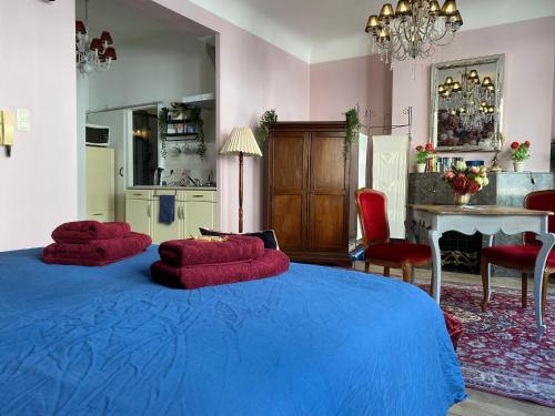 那慕尔The Pink Studio - Exceptional location IN city center - Unique & Elegant的一间卧室,在蓝色的床上配有两个红色枕头