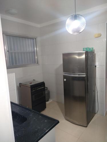 大普拉亚Apartamento Boqueirao的厨房配有不锈钢冰箱和水槽