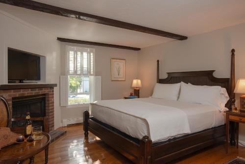 雅茅斯Liberty Hill Inn的一间卧室设有一张大床和一个壁炉