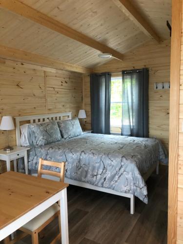 拜圣卡特琳Les chalets de la colline inc的小木屋内一间卧室,配有一张床