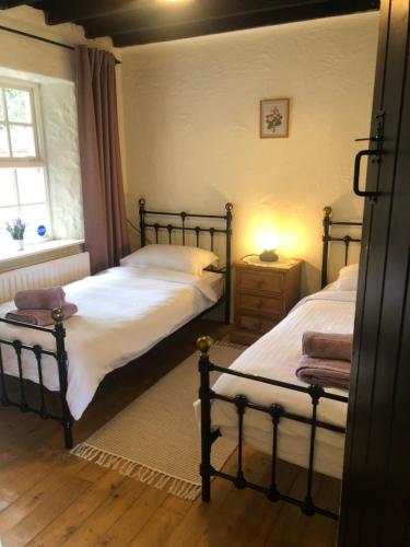 ArboeClannad Cottage的一间卧室设有两张单人床和一个窗户。