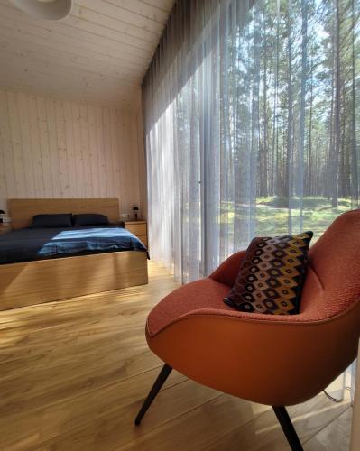 Beach House Trimpas的卧室配有床、椅子和窗户。