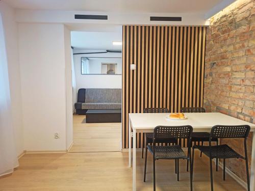 比亚韦斯托克Apartamenty W Domu的一间设有桌椅和砖墙的用餐室