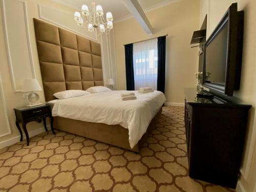 布加勒斯特Venetian Bucharest的一间卧室配有一张大床和一台平面电视