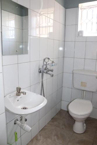 坎帕拉Luwafu Guest House的白色的浴室设有卫生间和水槽。