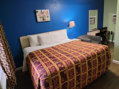 乔普林Plaza Motel的一间卧室配有一张蓝色墙壁的床