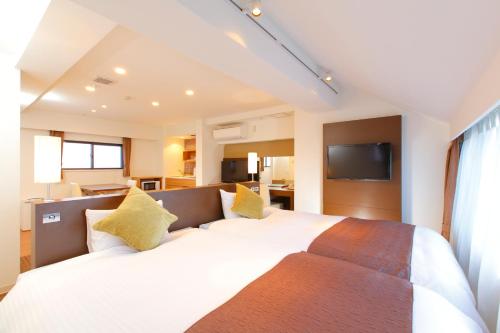 东京FLEXSTAY 饭田桥旅馆的卧室配有一张带黄色枕头的大型白色床。
